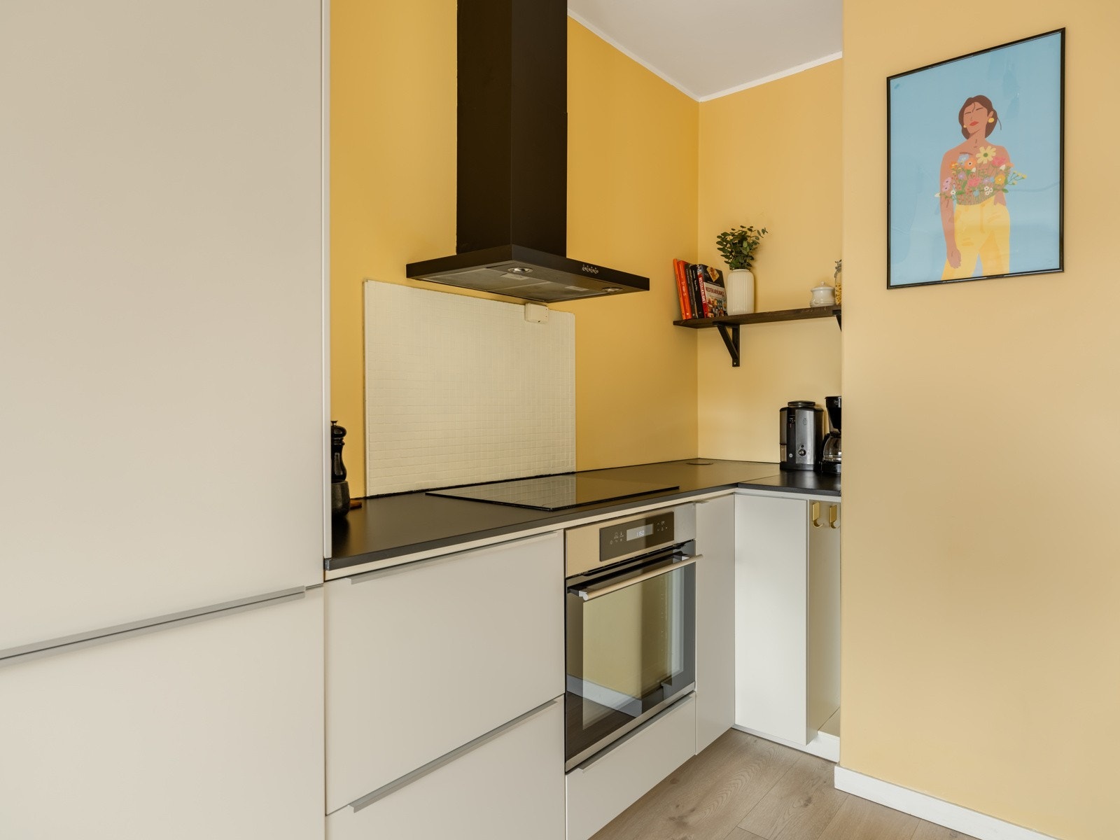 Innredning med slette fronter, laminat benkeplate, oppvaskkum, ventilator, malte fliser over benk, belysning under overskap og avløpspumpe. Galleribilde