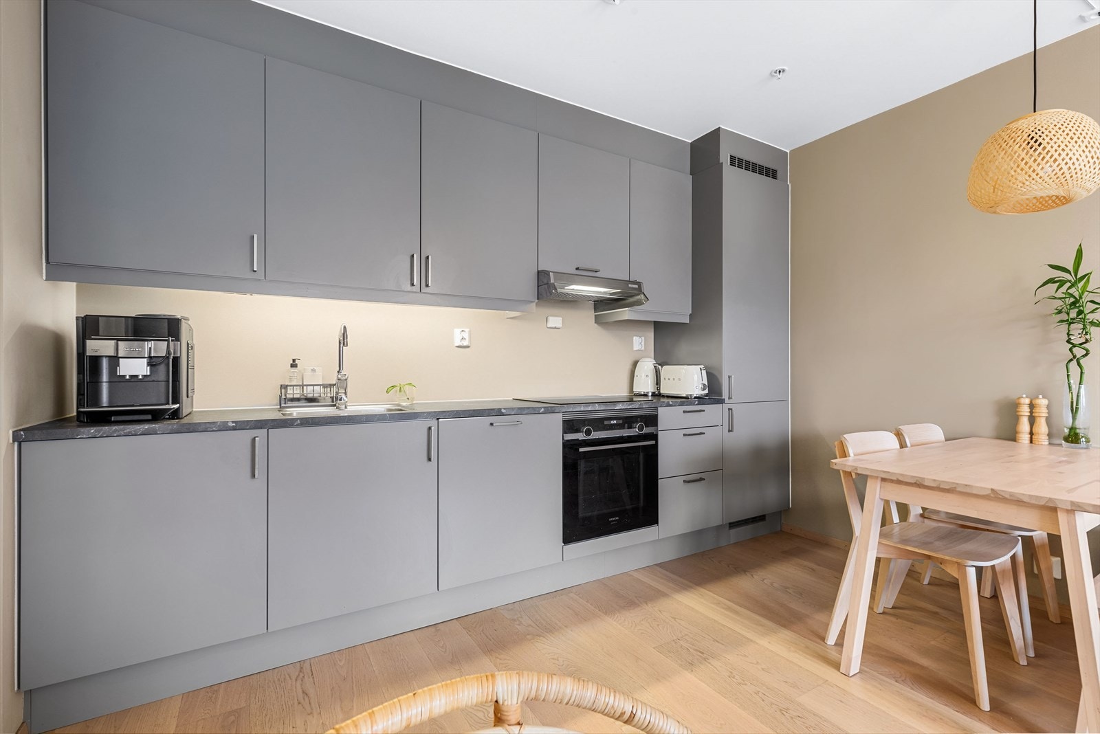 Kjøkkeninnredning med glatte fronter og foliert benkeplate. Galleribilde