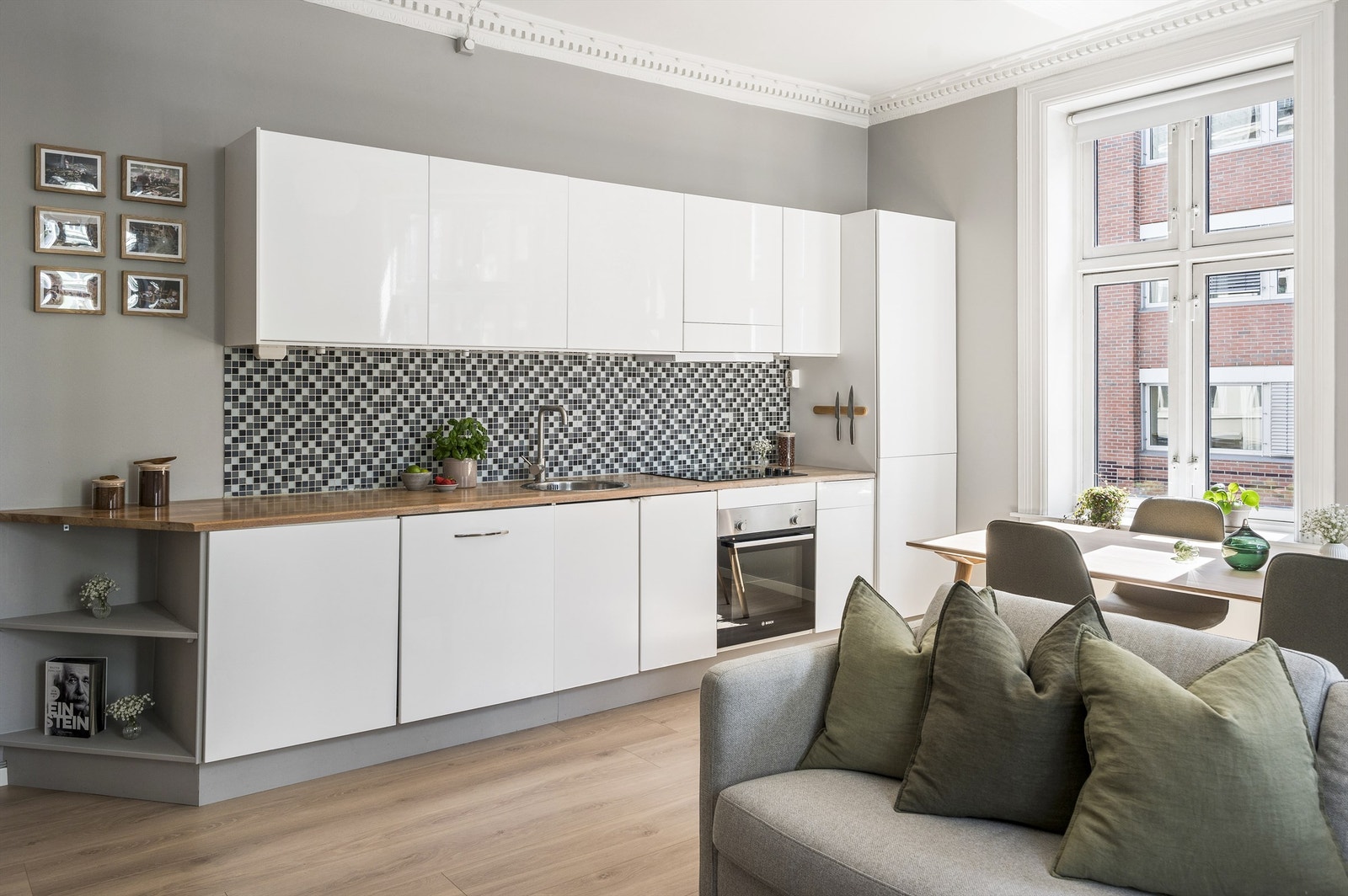 Stilrent og moderne kjøkken, med hvite, glatte fronter. Flott benkeplate i tre med god arbeidplass. Kjøkkenet har gode oppbevaringsløsninger i benkeskap og overskap. Stikkontakter over kjøkkenbenk. Galleribilde