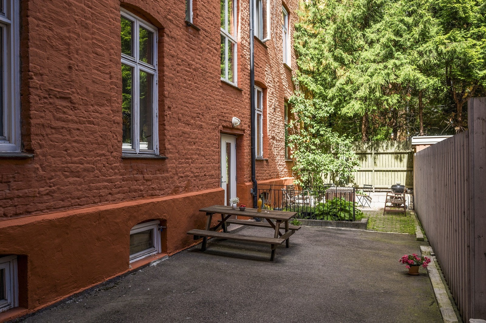 Lukket, felles bakgård i borettslaget med sittegrupper og liten plen. Det er sol i felles bakgård fra morgen og frem til ca kl 14 sommerstid. Galleribilde
