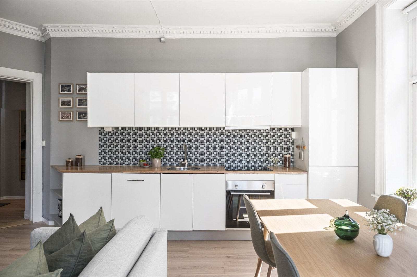 Hvitevarene er integrerte og medfølger handelen. Det er belysning og ventilator i overskap med kullfilter. Det er plass til stort spisebord i tilknytning til kjøkkensonen i leiligheten. Galleribilde