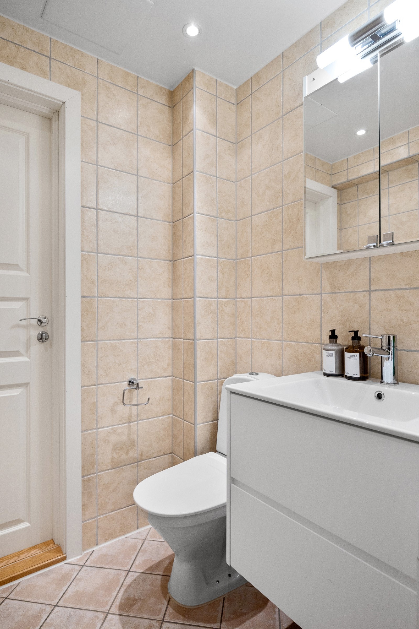 Flislagt gulv med gulvvarme, flislagte vegger og malt himling med downlights. Avtrekksventil i vegg. Galleribilde