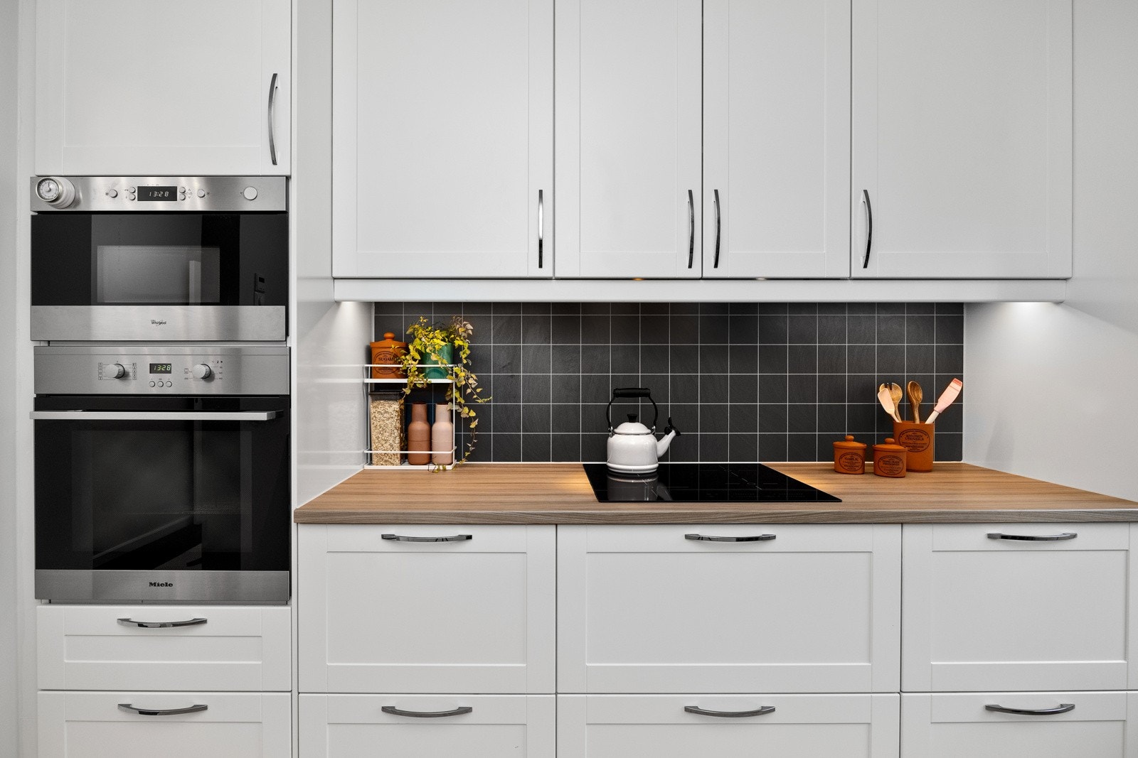 Det er montert benkeskapsbelysning og stikkontakter under overskap. Galleribilde