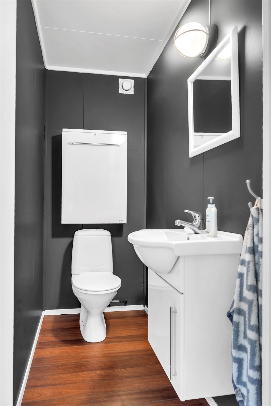 Separat toalettrom med parkett på gulv og malte overflater for vegger / himling. Det er gulvmontert toalett og servant med ett-greps blandebatteri. Galleribilde