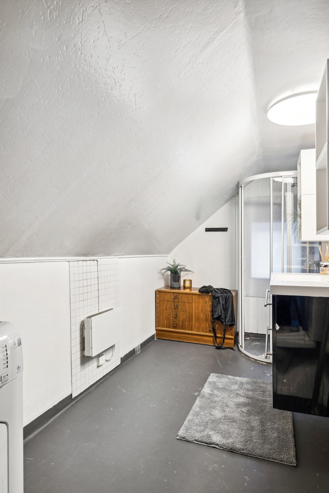 Baderom 2.etg er innredet med servant med underskap, speil med tilhørende belysning, gulvmontert toalett, dusjdører, det er opplegg for vaskemaskin. Galleribilde