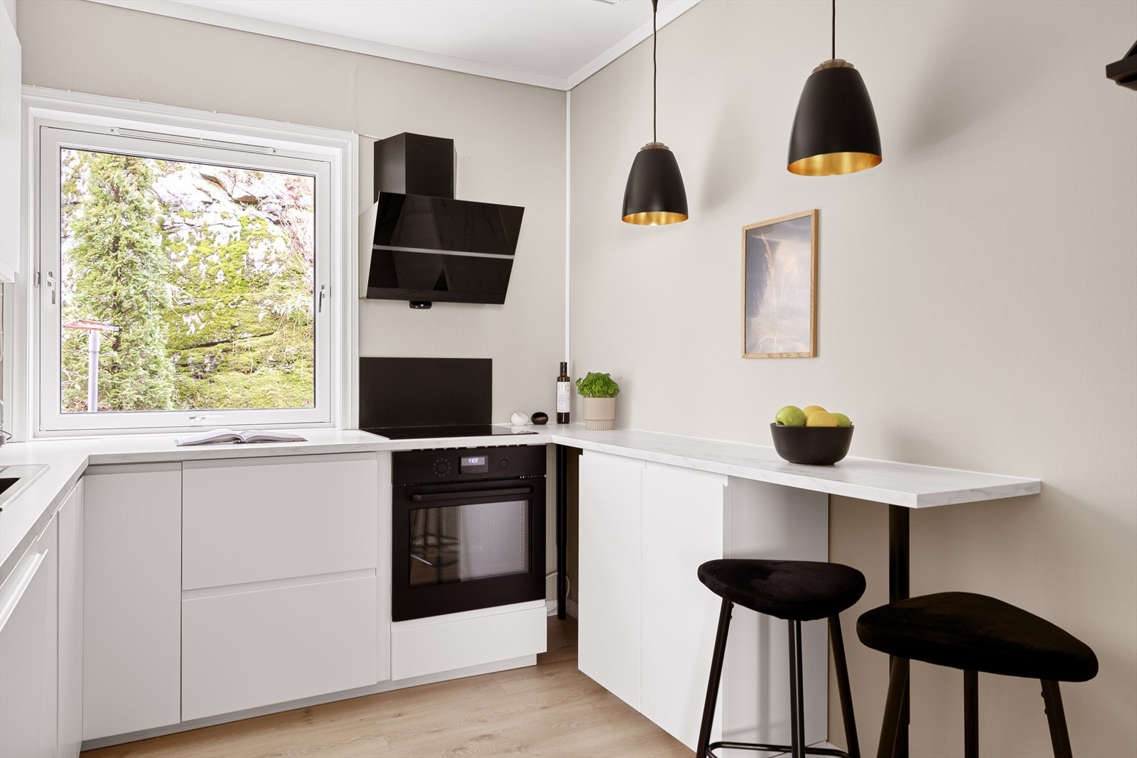 En liten, praktisk kjøkkenøy med plass til barstoler, gir en hyggelig plass til å nyte morgenkaffen eller frokosten, samtidig som den fungerer som en naturlig forlengelse av kjøkkenet. Galleribilde
