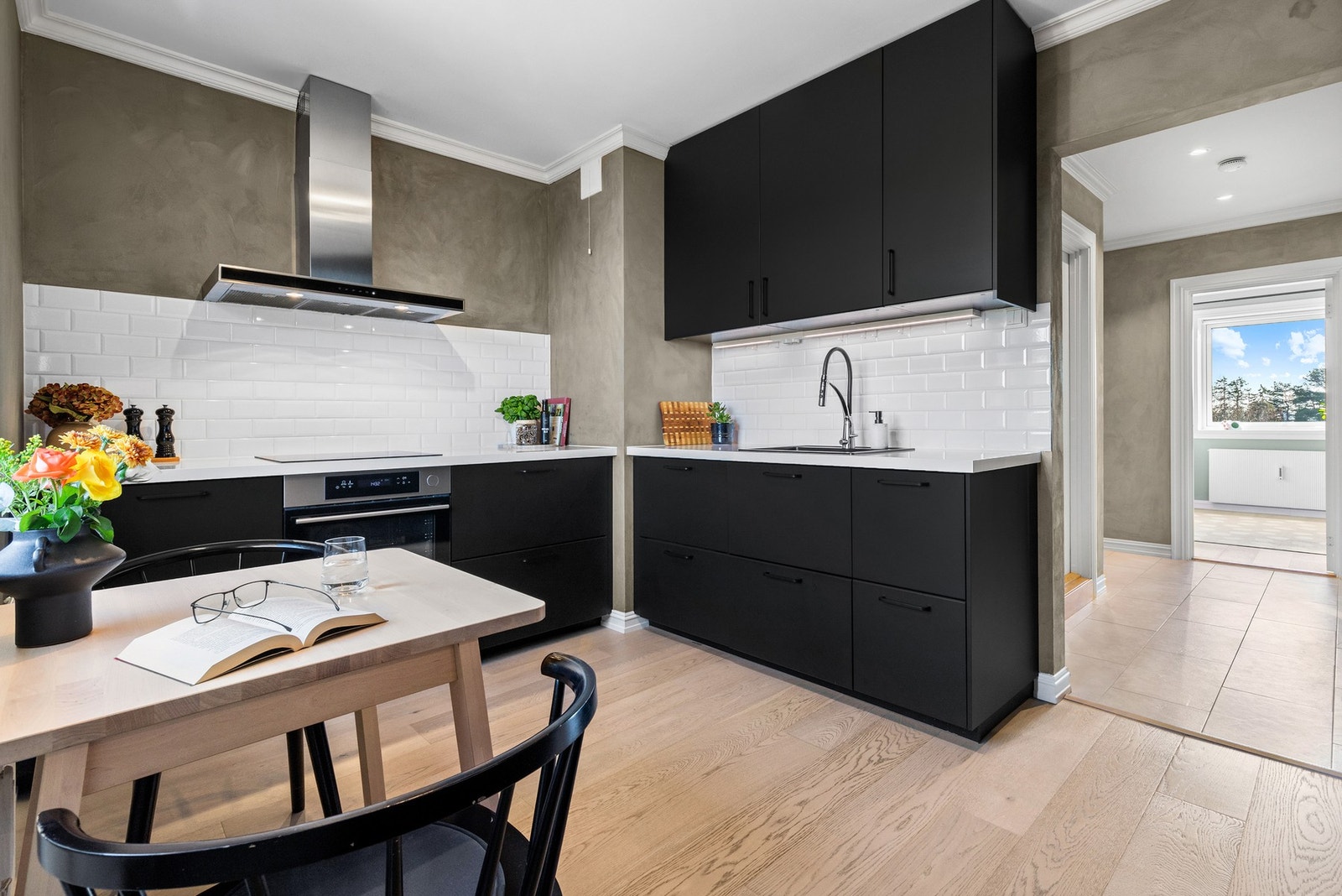 Det er lagt hvite metrofliser over benken og montert god benkebelysning. Kjøkkenet er utstyrt med integrert induksjonstopp, stekeovn, oppvaskmaskin og kjøl/frys. En kullfilterventilator i børstet stål er montert over kokesonen Galleribilde