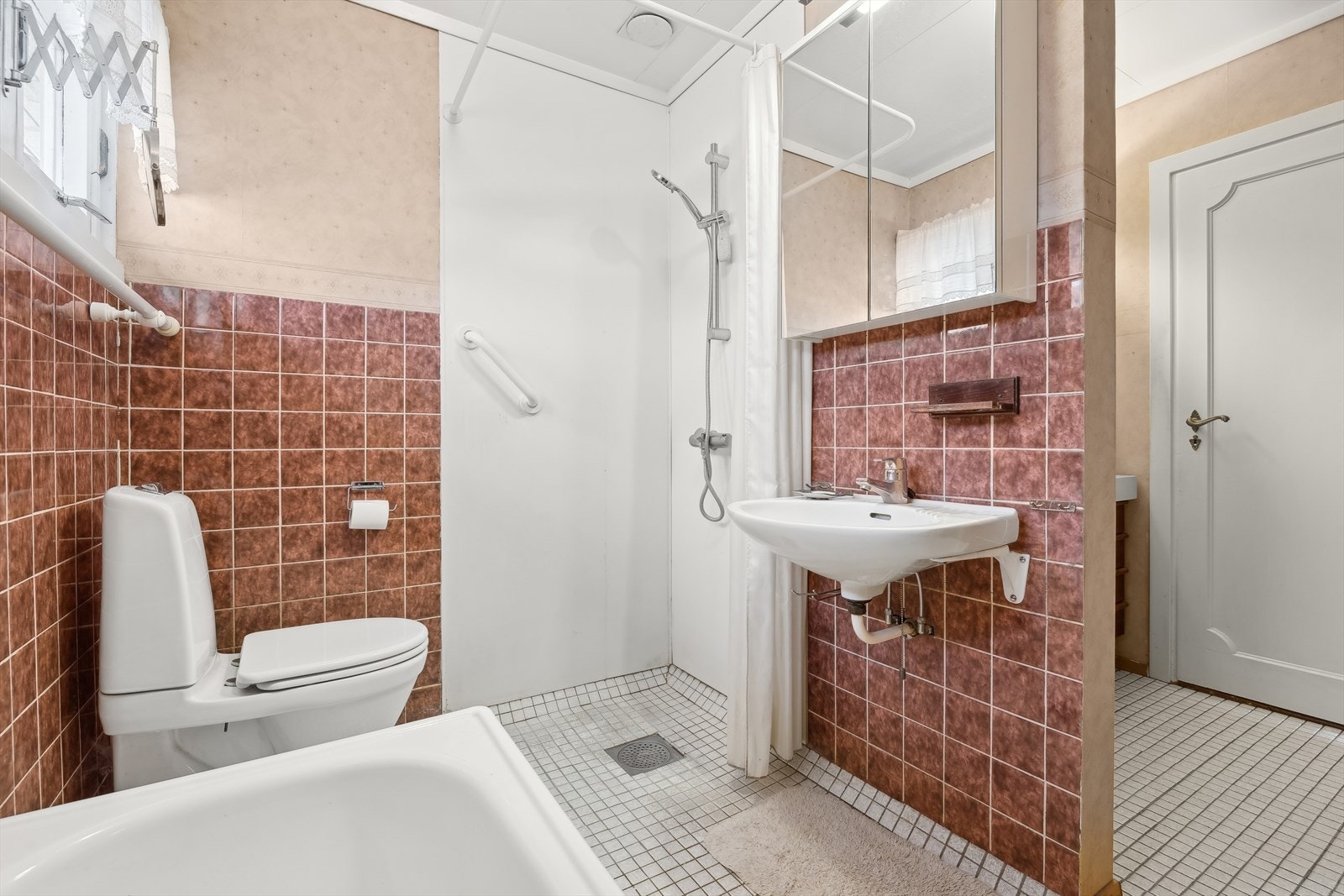 Mosaikk gulvfliser, fliser på vegg i brystning fra byggeår/tapet over fra 2014 og våtromsplater i dusj fra 2014. Badekar er også montert. Galleribilde