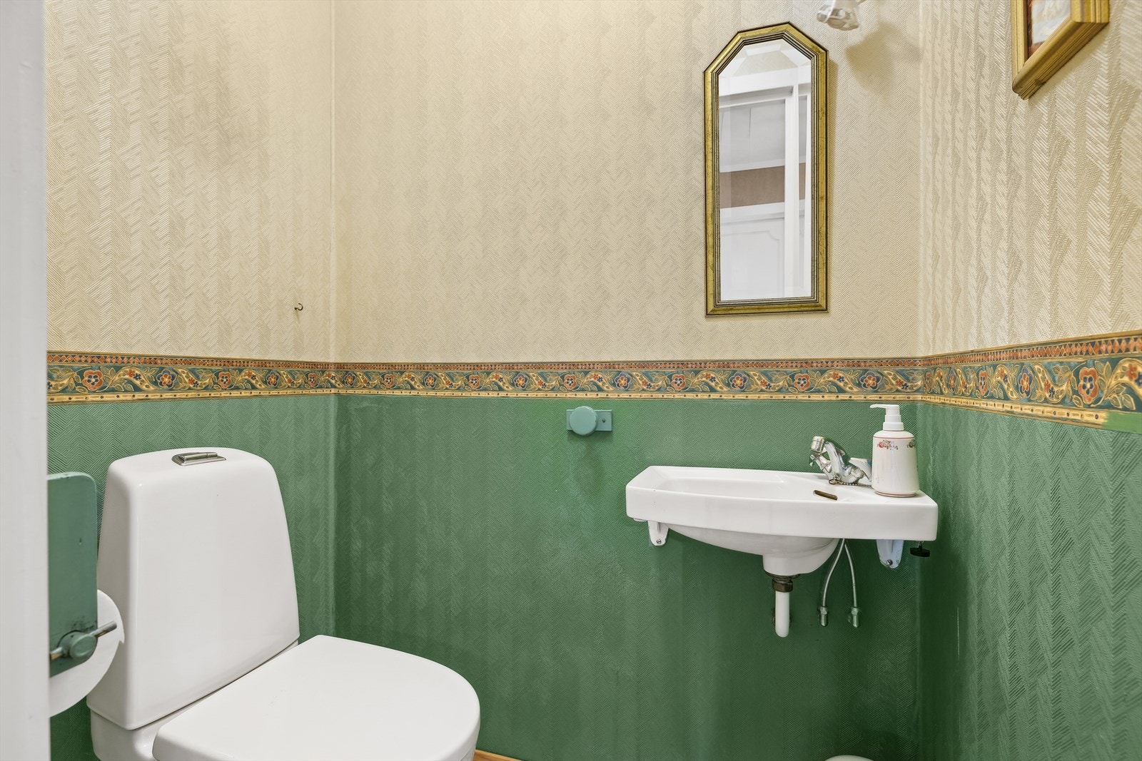 WC-rom i 1. etasje har gulvvarme, håndvask, toalett fra 2014, mosaikk på gulv og malt tapet på vegger. Galleribilde