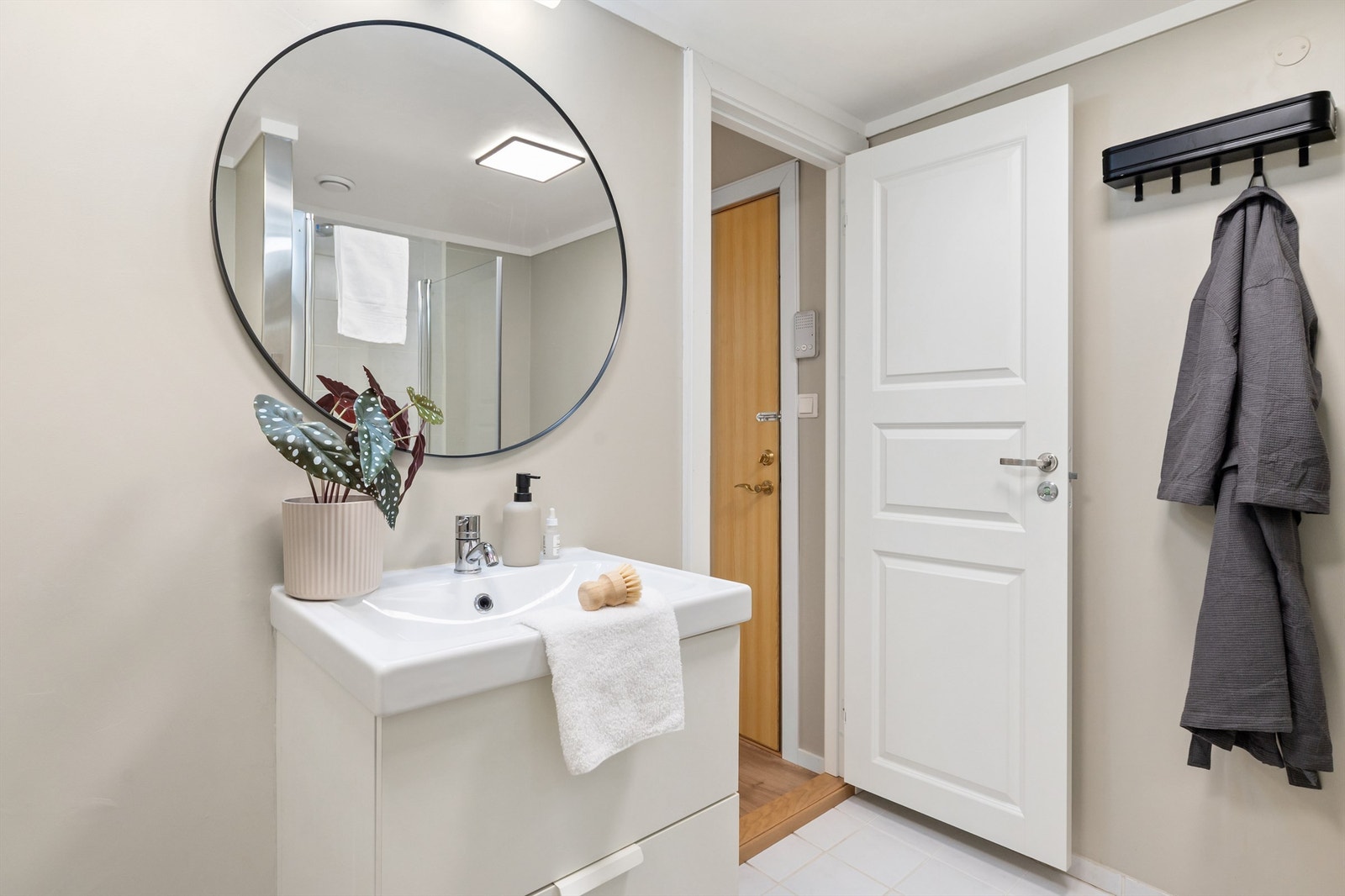 Badet er innredet med servant, speil, wc og dusjhjørne. Galleribilde