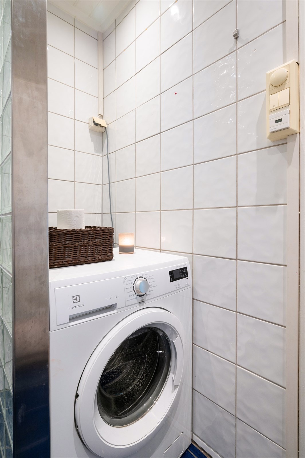 Badet er innredet med klosett, servant med underskap, dusjnisje med vegger i glassbyggerstein og opplegg for vaskemaskin. Galleribilde