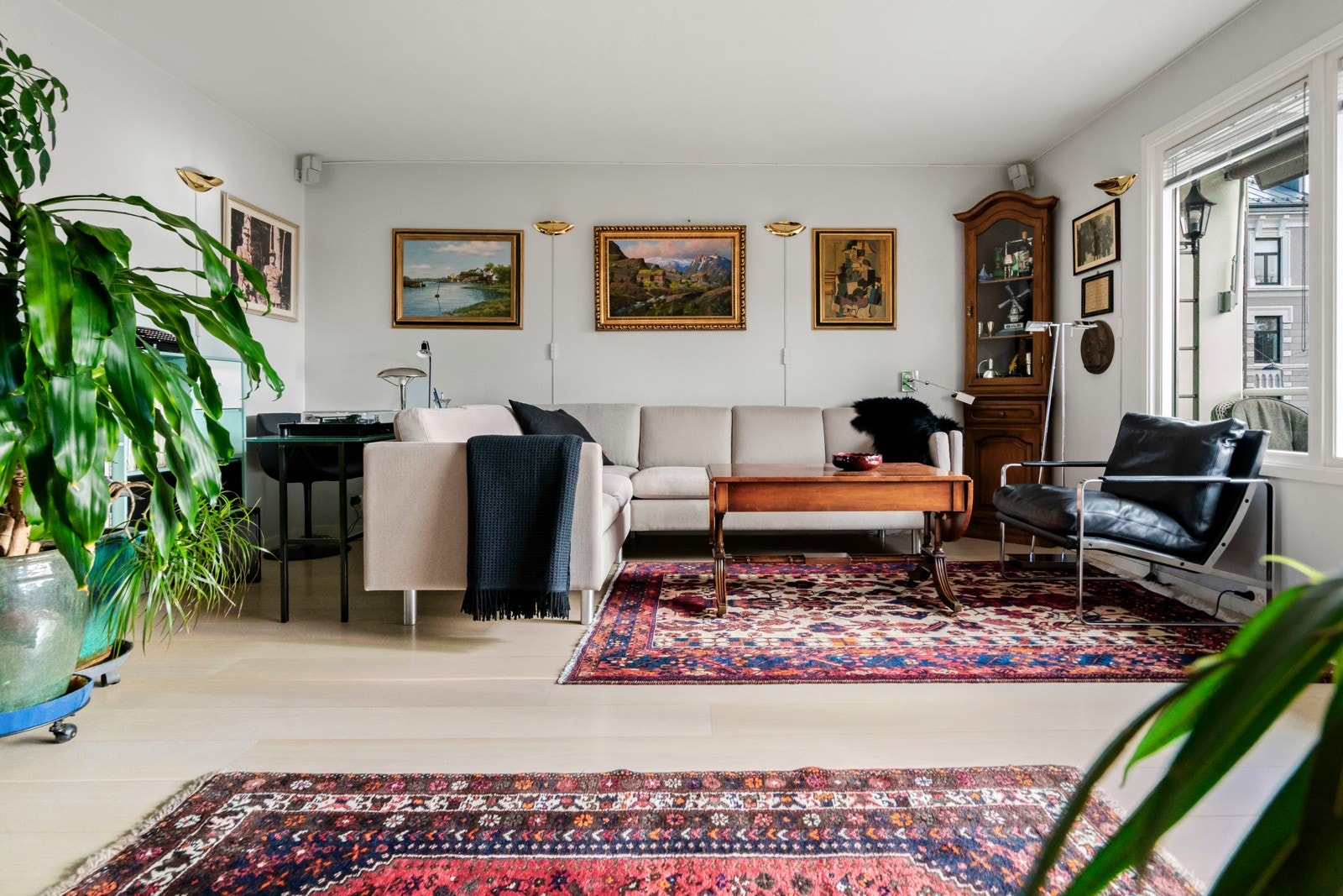 Stuedelen er tilbaketrukket fra kjøkkensonen og har plass til både sofagruppe og kontorplass og rikelig med veggplass for bilder og hyller Galleribilde