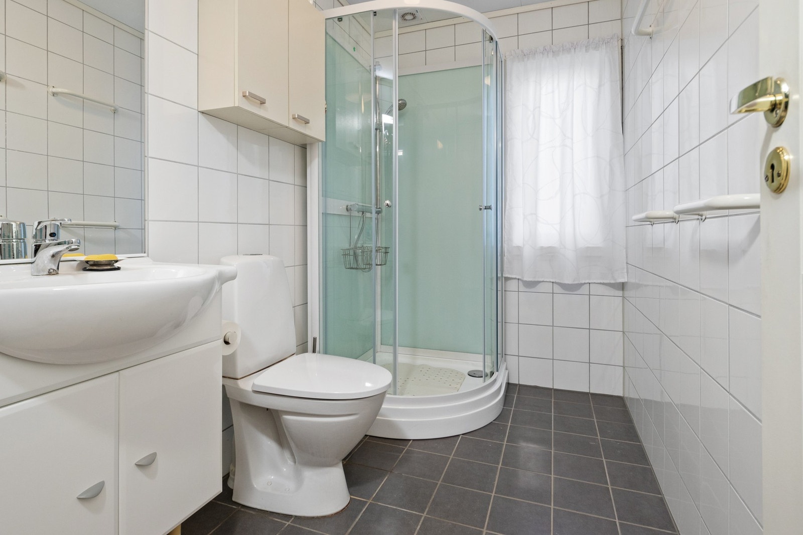 Badet ble pusset opp rundt 2010 og er innredet med grå gulvfliser og hvite fliser på veggene. Galleribilde