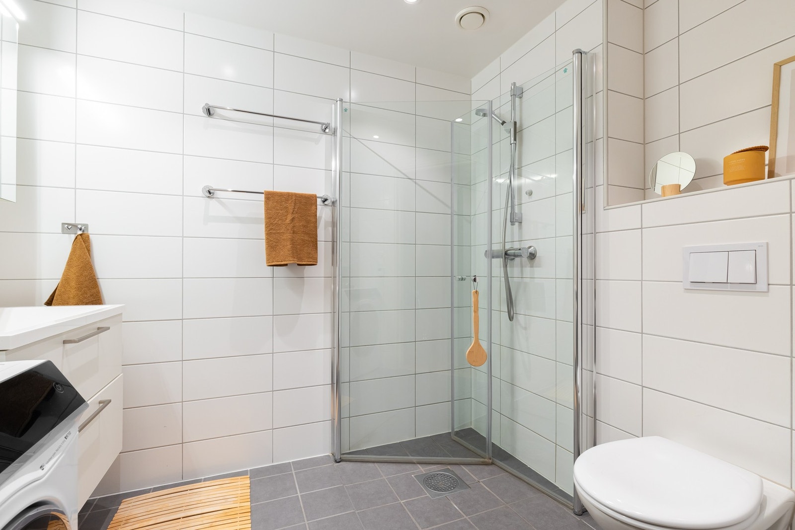 Dusjhjørne med svingbare glassdører som frigjør plass på gulvet. Opplegg for vaskemaskin. Galleribilde