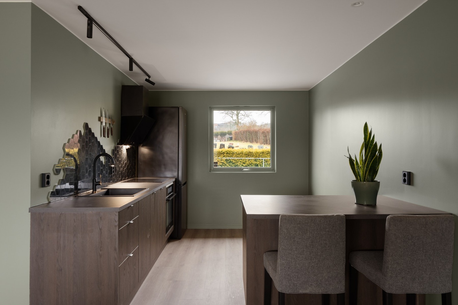 Moderne kjøkken med tidsriktige fronter og en kjøkkenøy som står praktisk til for sosialisering med gjester. Galleribilde