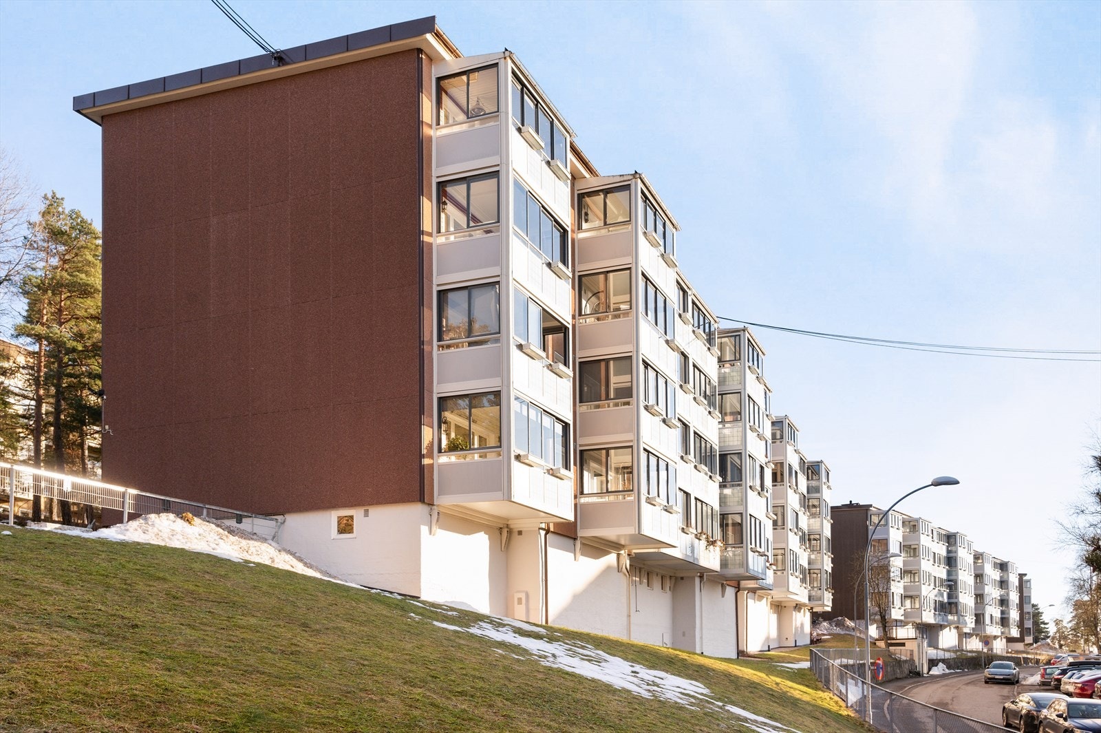 Pent opparbeidet felles tomt med plen, trær, diverse beplantning, sittebenker, lekeplass og asfalterte internveier. Galleribilde