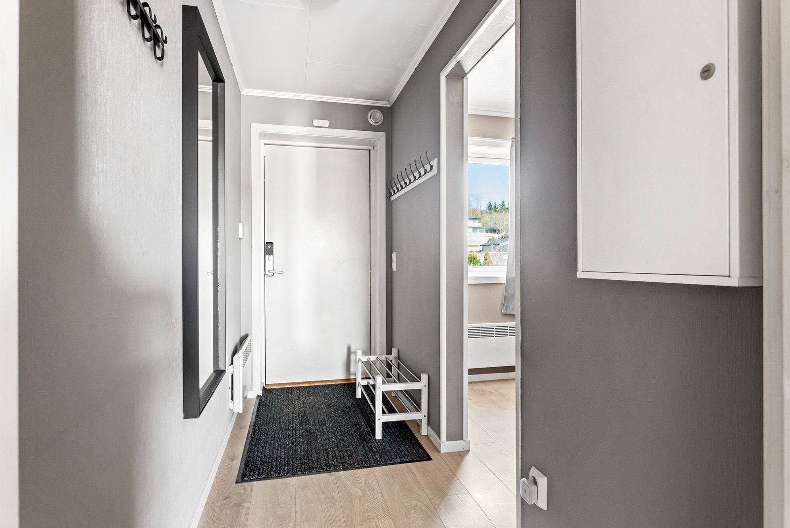 Entréen gir et godt førsteinntrykk av leiligheten og her er det plass til oppheng av yttertøy, samt plassering av sko. Galleribilde