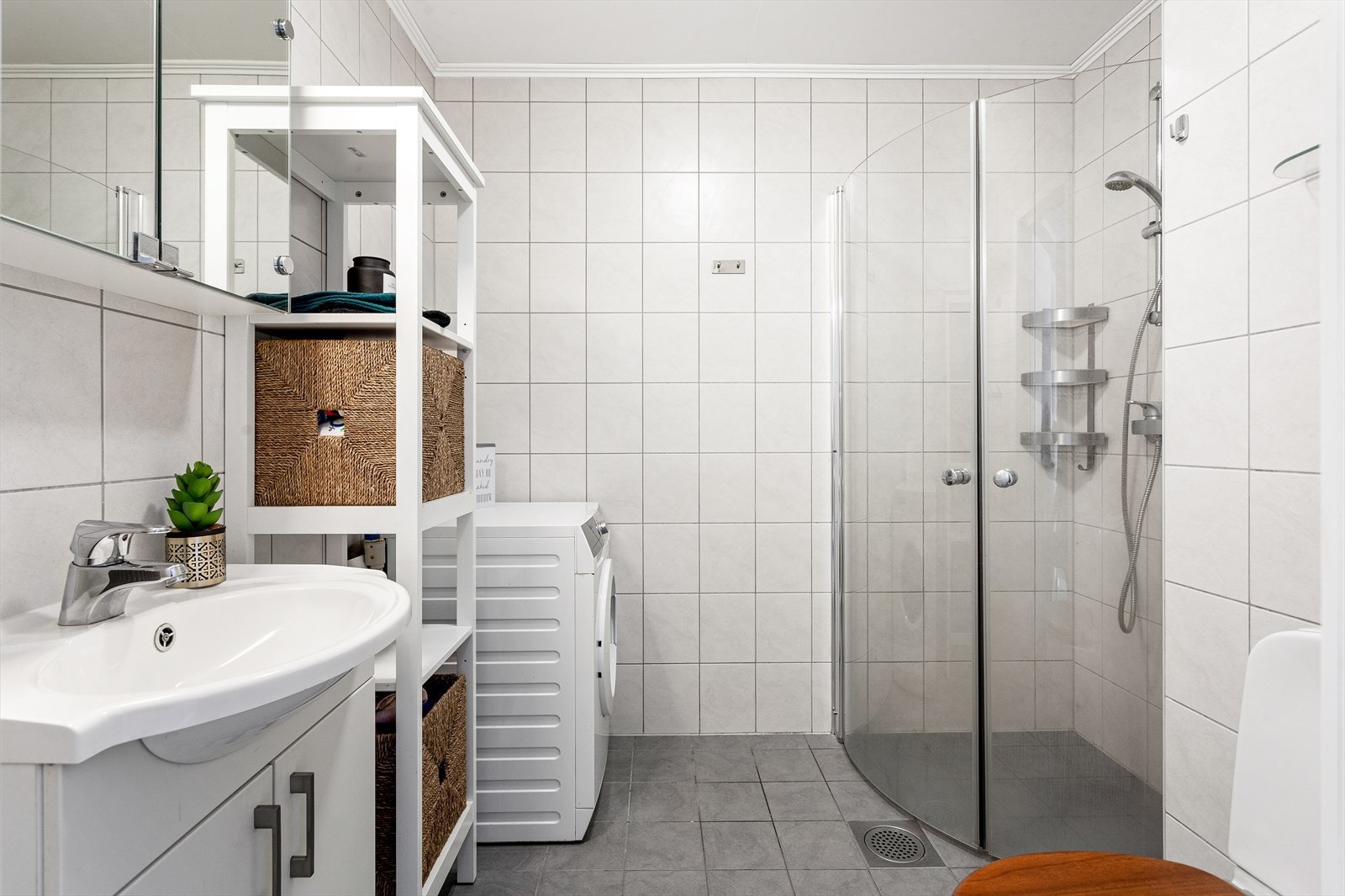 Speilskap i overkant av servant og opplegg for vaskemaskin. Galleribilde