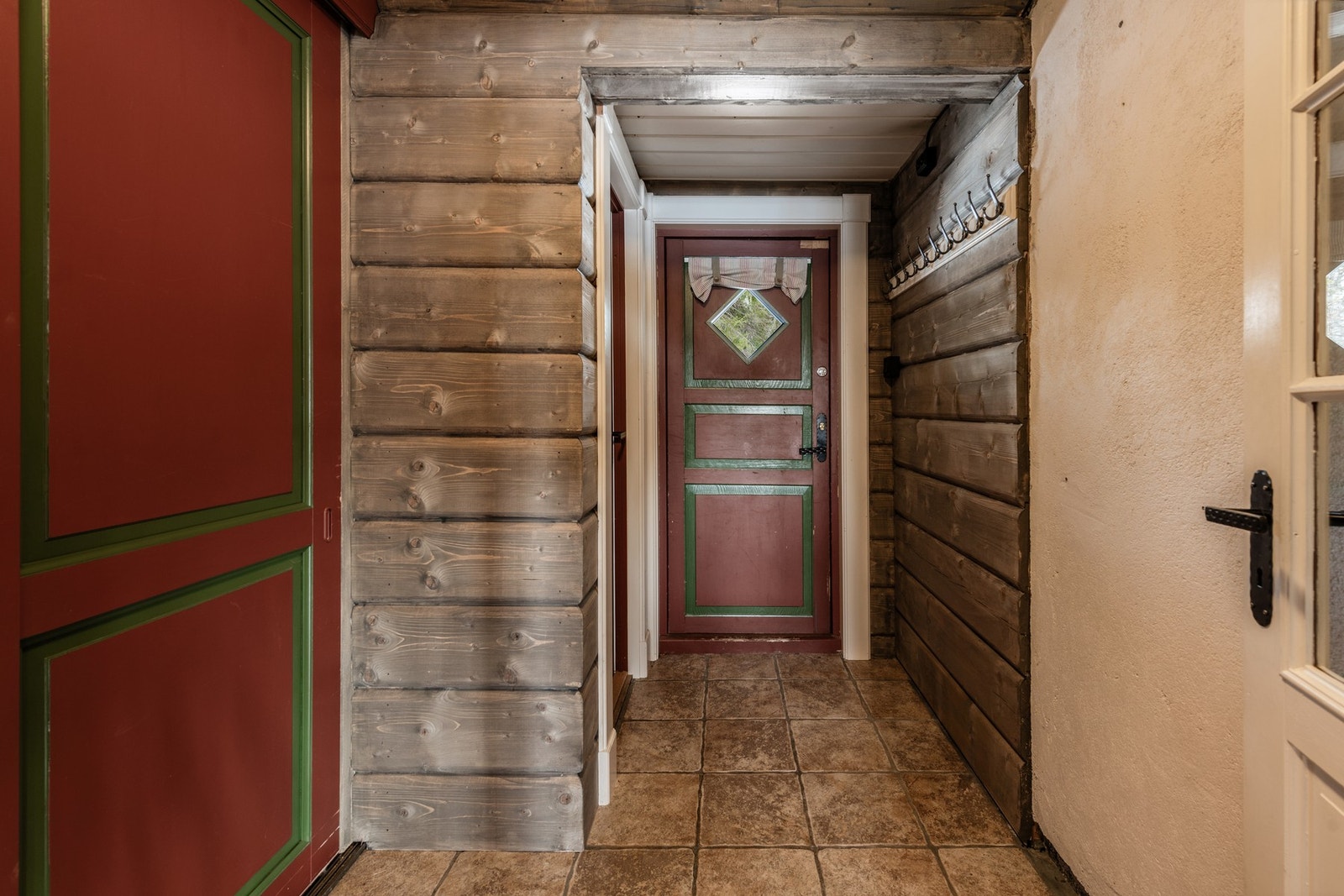 Du ankommer hytten til en flislagt entre med plassbygd skap. Galleribilde