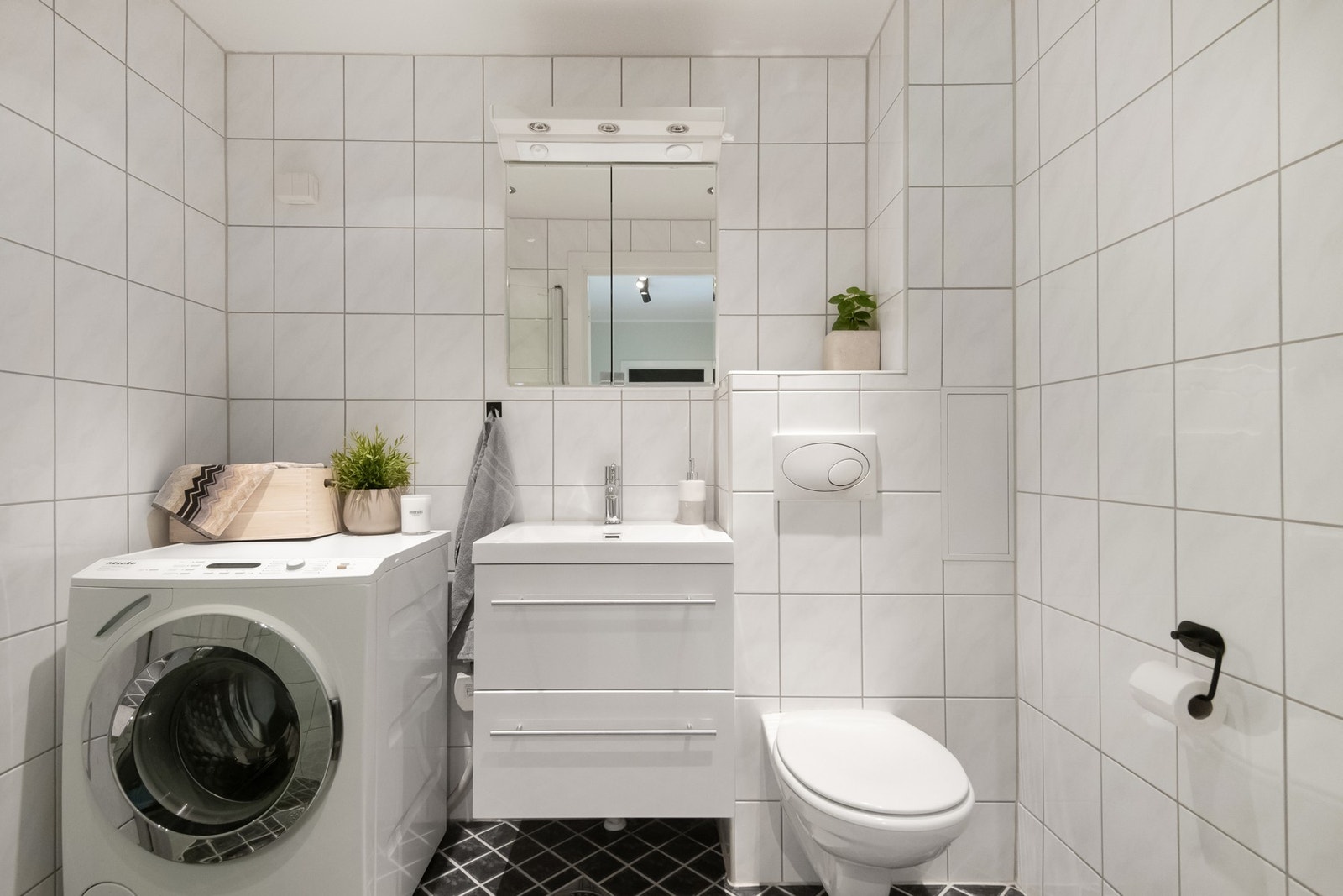 Badet har et tidløst uttrykk med flislagte overflater og gulvvarme. Galleribilde