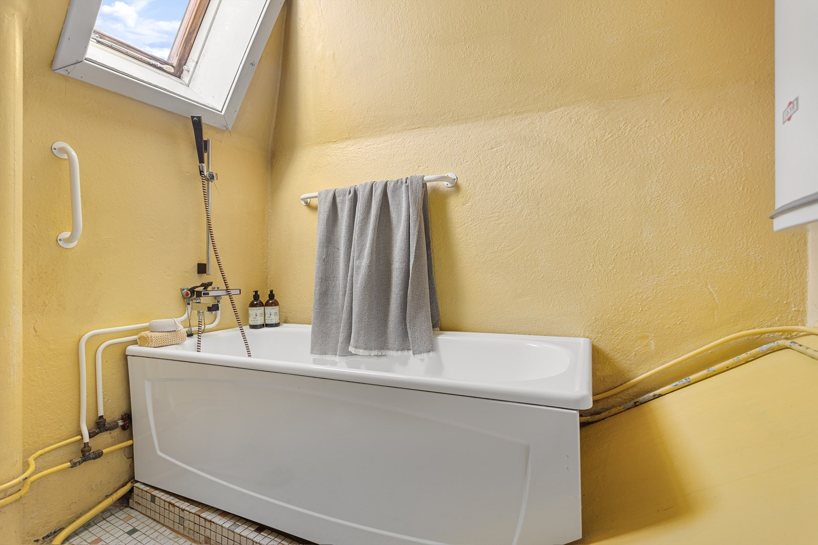 Badet er utstyrt med wc, servant og dusj i badekar. Naturlig ventilasjon. Det er flislagt gulv, malte pussete veggflater og malt himling. Galleribilde