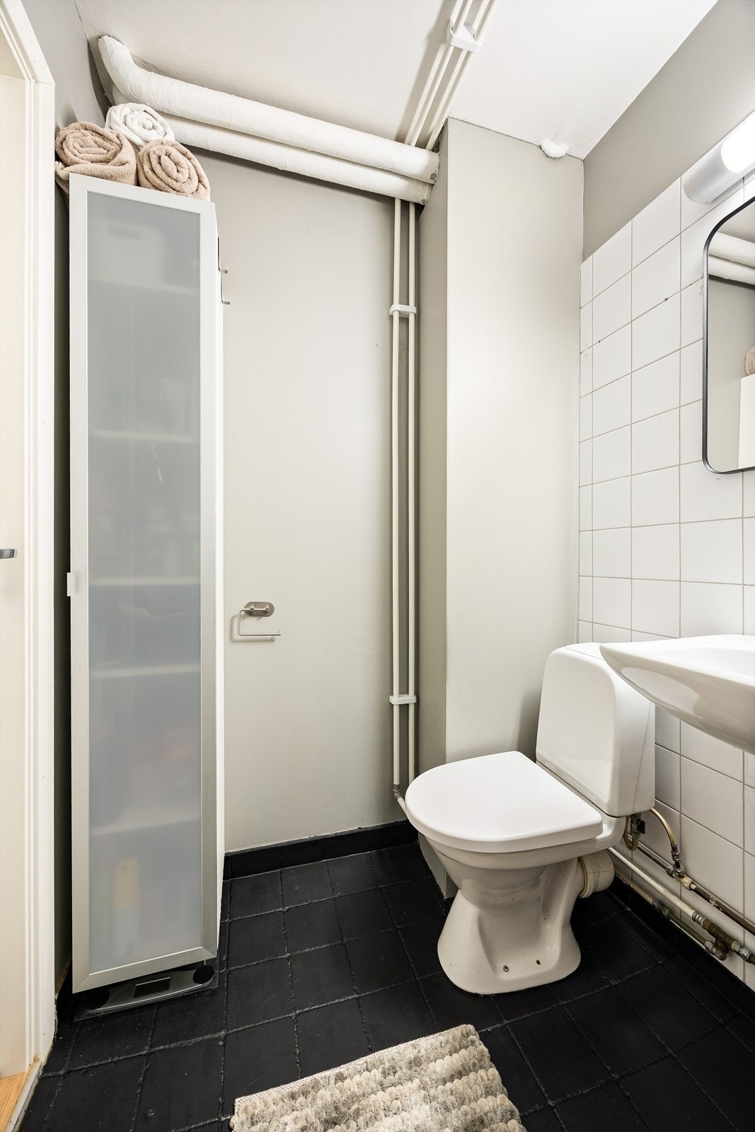 Baderommet er innredet med klosett, servant og dusjhjørne med forheng. Galleribilde