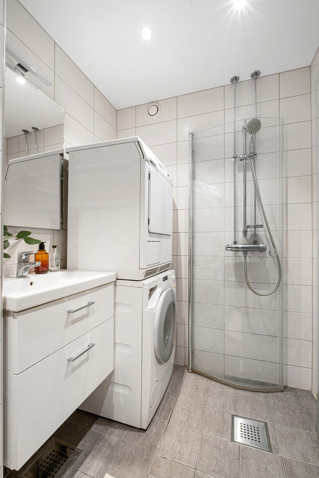 Flislagt baderom fra 2015/16 med varme i gulvet og downlights i himling - Baderommet er innredet med vegghengt klosett, servant med innredning og dusjhjørne med svingbare glassdører Galleribilde