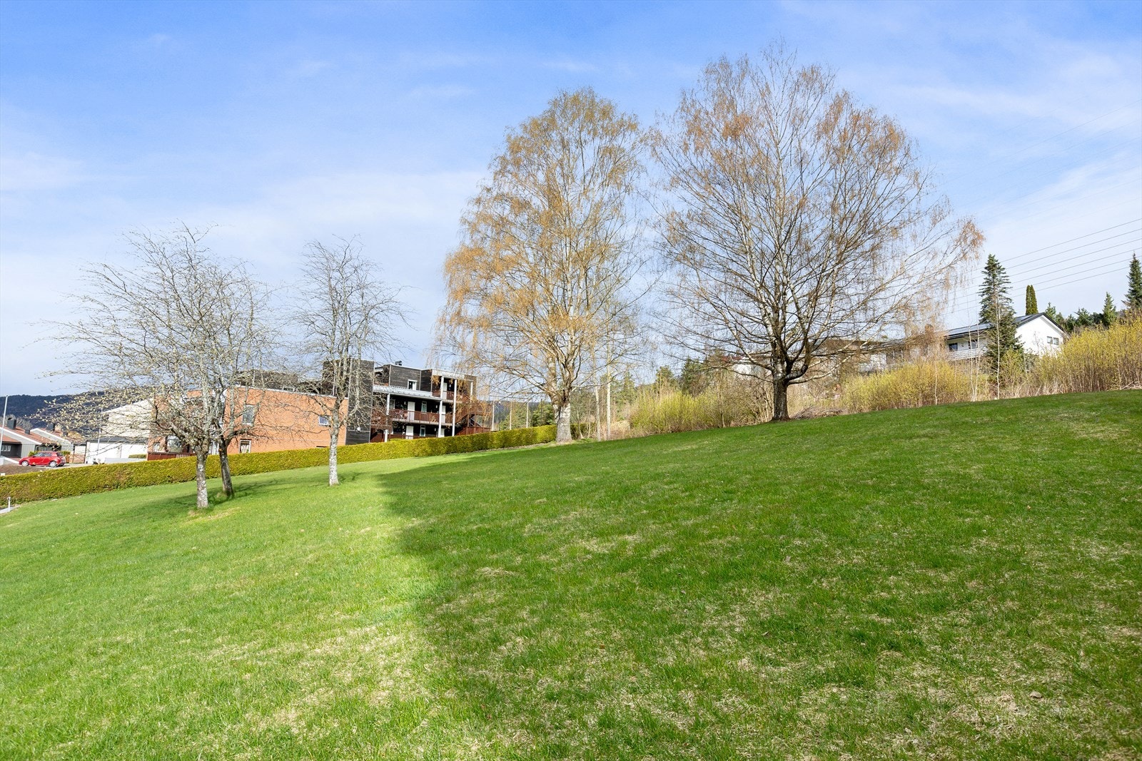 Det er pene gressarealer som kan benyttes til både piknik, soling og lek Galleribilde