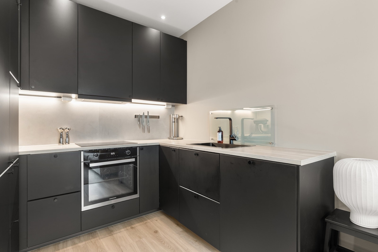 Hvitevarene er sømløst integrert i innredningen og består av stekeovn, platetopp, oppvaskmaskin og kjøleskap med fryser. Galleribilde