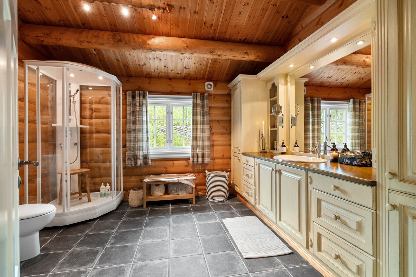 Det pene baderommet har flislagte gulv med behagelig gulvvarme og tømmervegger. Galleribilde