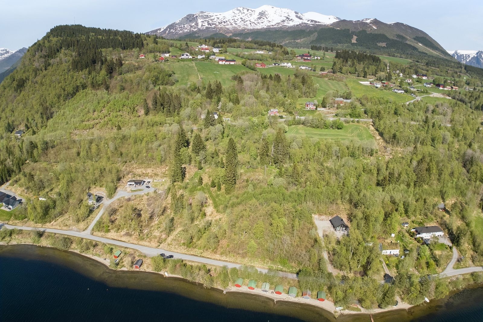 Dronebilde av nærområde. Naust ved Vatnevatnet og eigedomen opp mot Bondalseidet i bakgrunnen Galleribilde