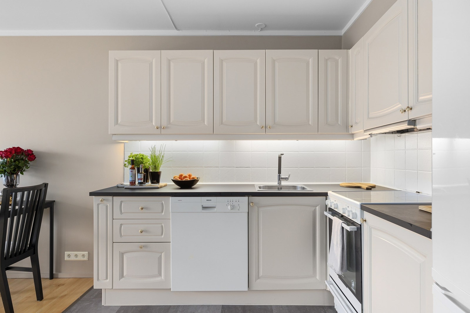 Lys kjøkkeninnredning med profilerte fronter og laminert benkeplate Galleribilde