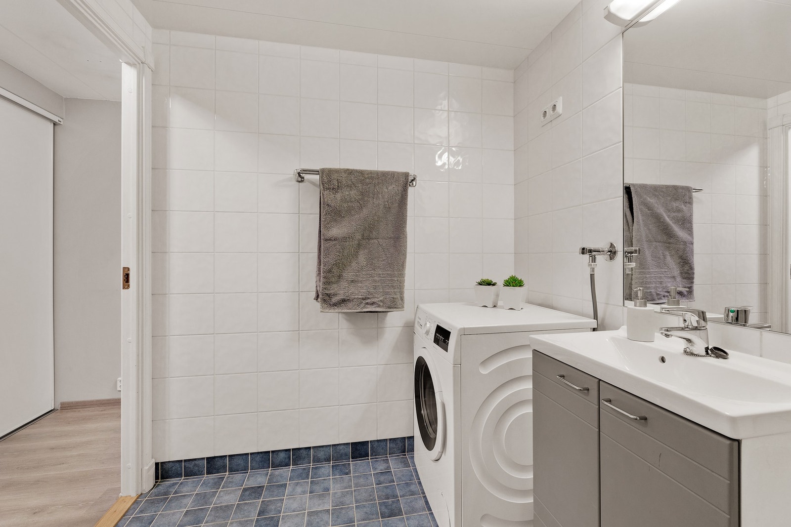 Badet har varmekabler i gulv og opplegg for både vaskemaskin og tørketrommel Galleribilde