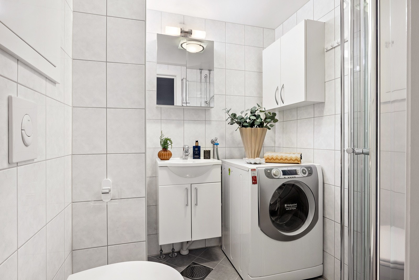 Flislagt bad fra 2014 -2016. Baderomsinnredningen er bestående av servant med underskap, speilskap med overlys, vegghengt klosett, dusjhjørne med svingbare glassdører og opplegg for vaskemaskin. Galleribilde