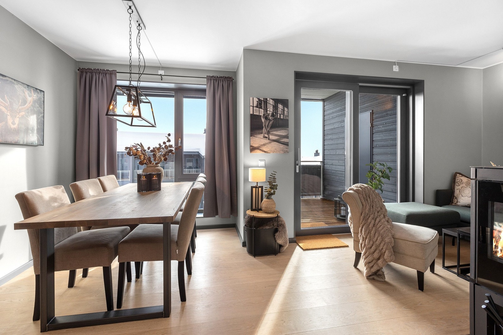 Lyst og moderne rom med spiseplass og stue, store vinduer som slipper inn mye naturlig lys, samt utgang til balkong. Solskjerming på vinduene. Galleribilde