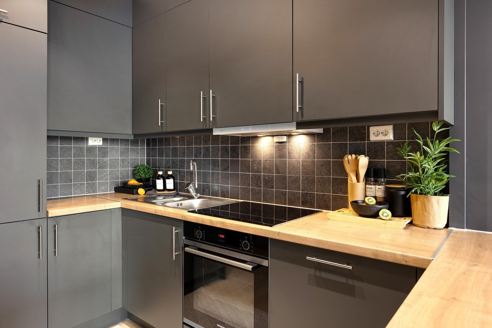 Flislagt vegg og benkeplater i tre. God belysning under overskapene. Galleribilde