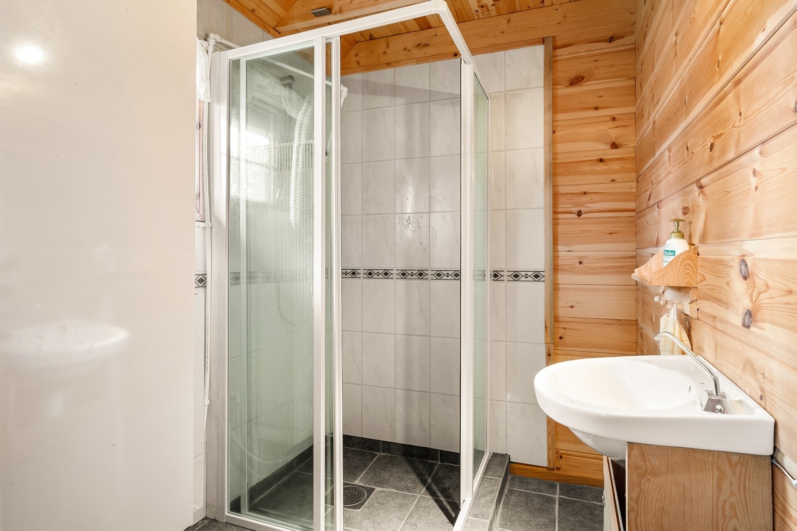 Veggene har panel/tømmer og baderomsplater. Gulvet er flislagt. Galleribilde