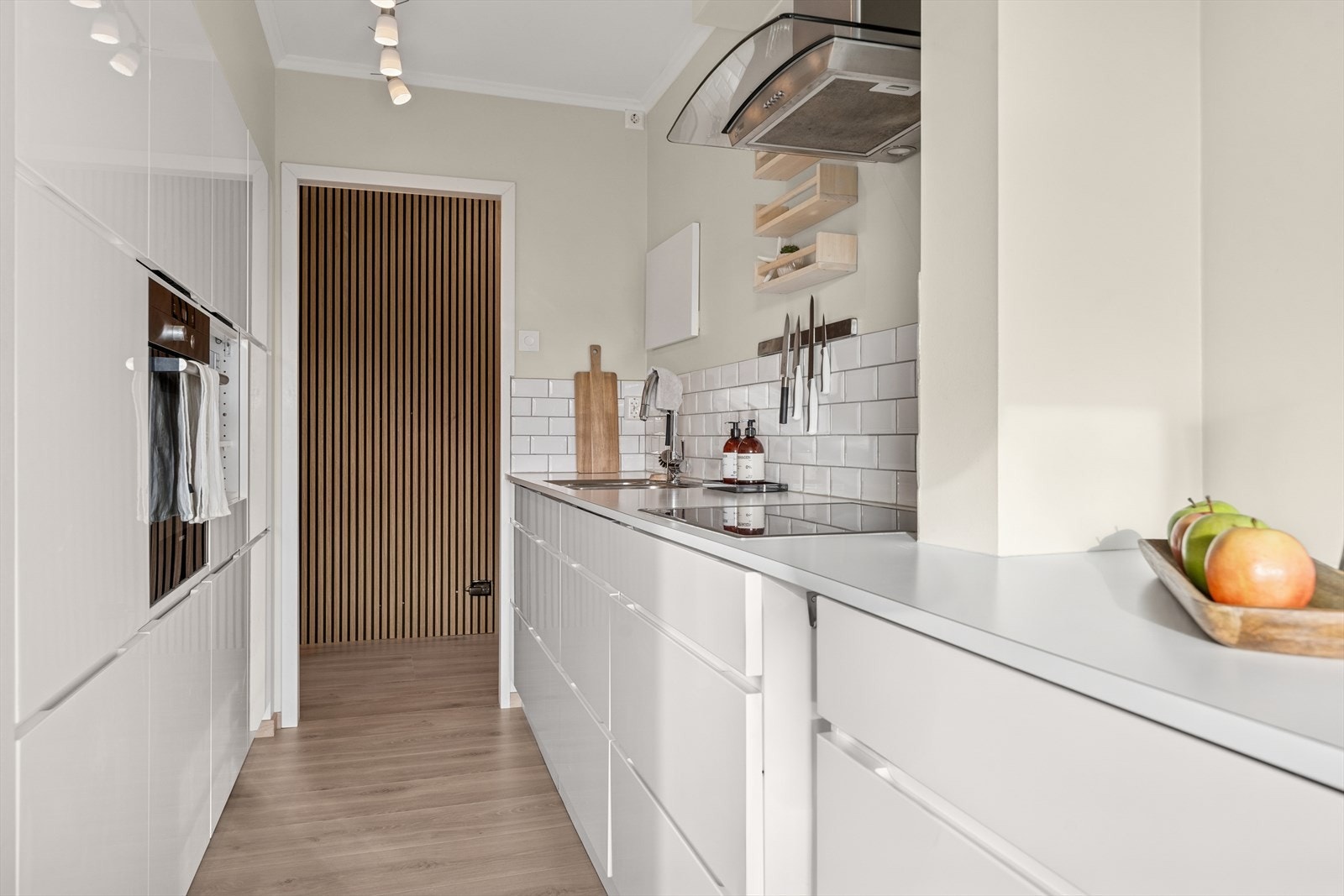 Kjøkkeninnredningen består av hvite, slette fronter med benkeplate i laminat. Galleribilde