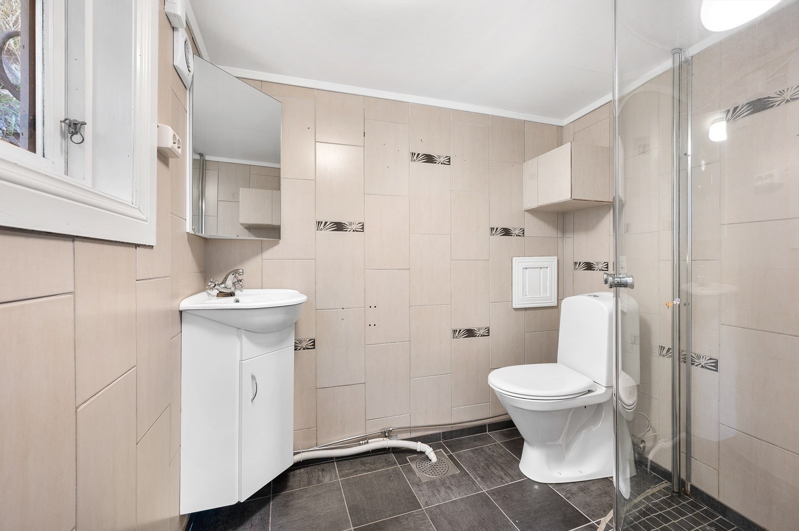 Bad med servant, toalett og dusjhjørne med glassvegger. Galleribilde