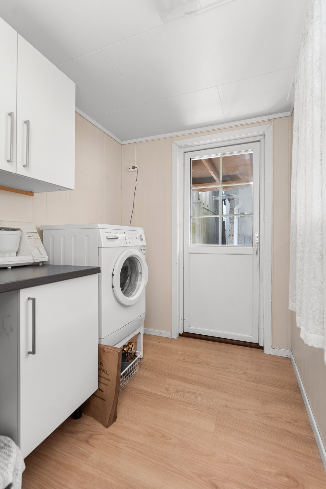 Leiligheten har eget vaskerom med utgang til bakgårsden. Galleribilde