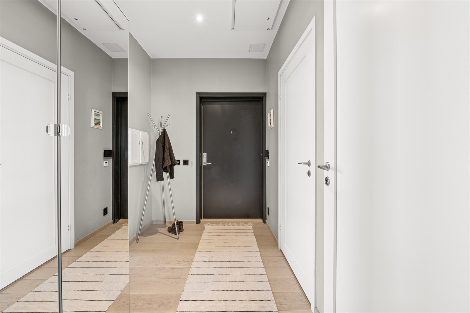 Velkommen inn i en romslig entré med garderobeskap og porttelefon med video Galleribilde