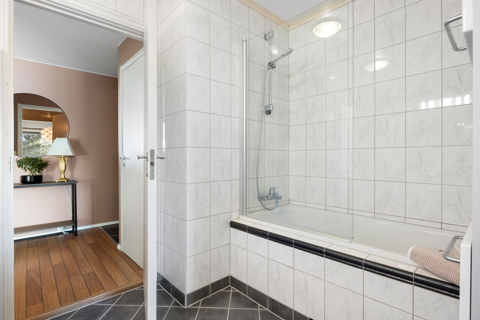 Flislagt baderom med varme og badekar Galleribilde