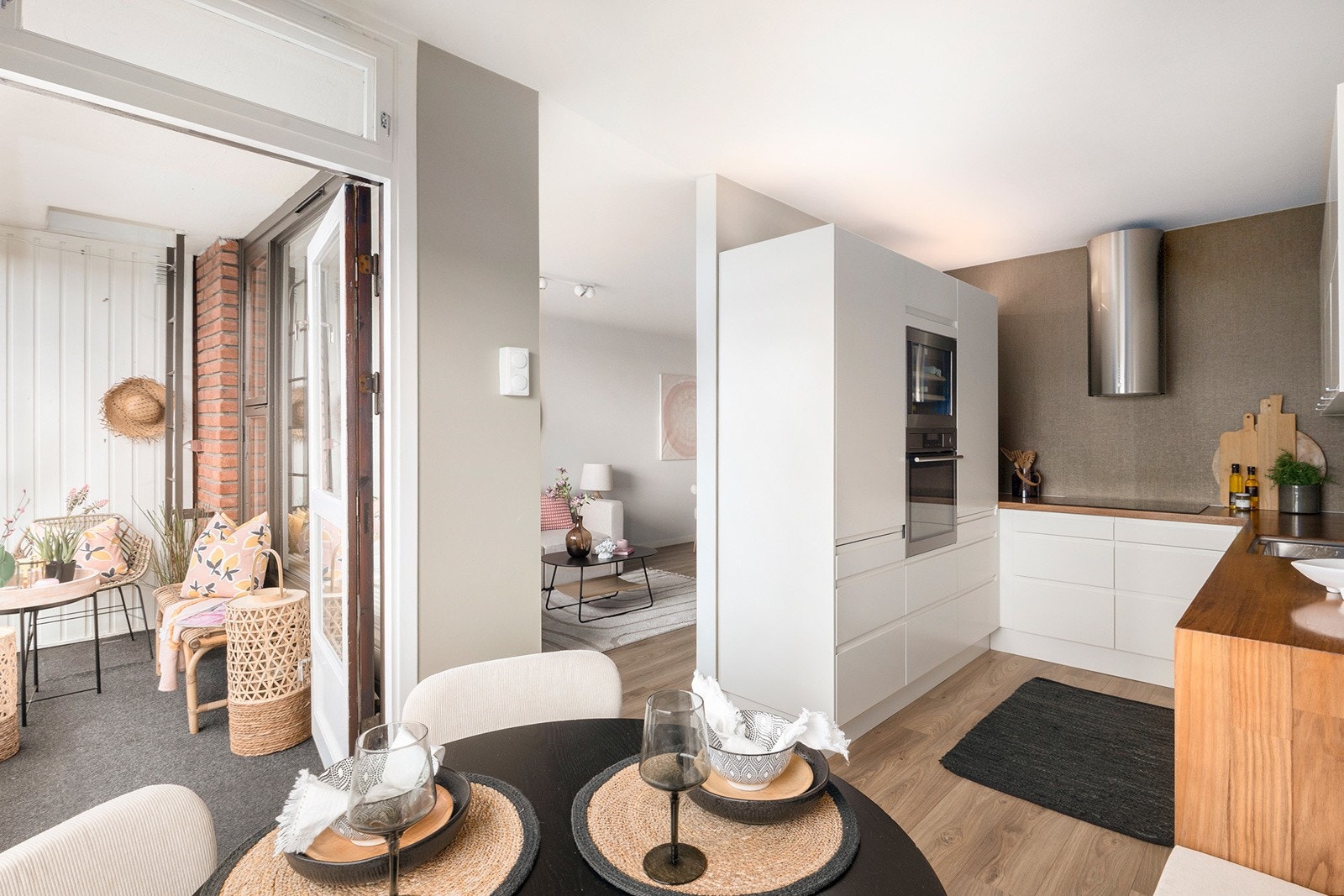 Delvis åpen og sosial kjøkkenløsning med god flyt mellom stue, kjøkken og balkong Galleribilde