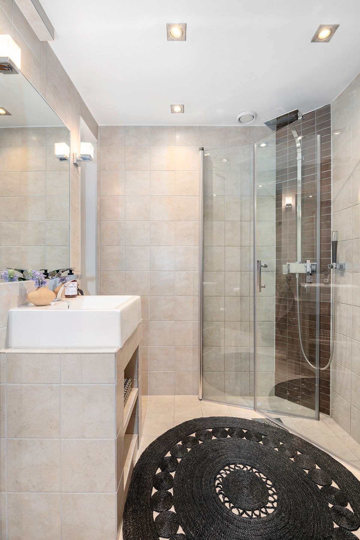 Dusjhjørne med hånddusj og regndusj. Plassbygde hylleløsninger i nisje ved siden av vasken Galleribilde