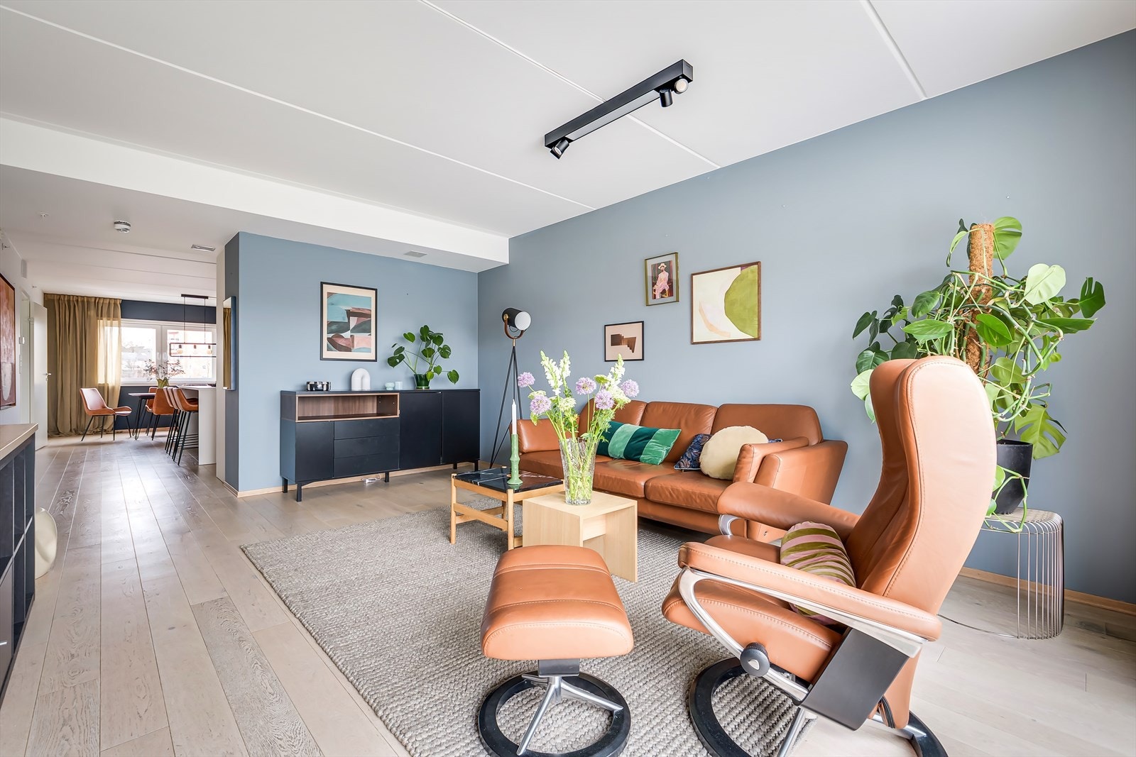 Delvis åpning mellom stue og kjøkken gir et stort, sosialt allrom, samtidig som sonene blir naturlig definerte. Galleribilde