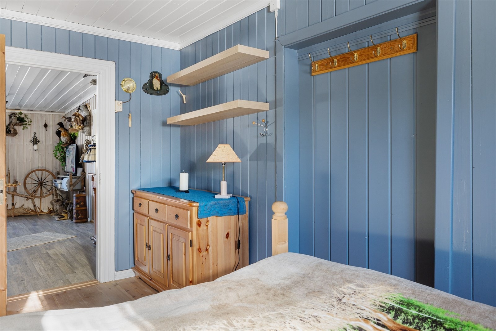 Soverommet har pent enstavs gulv og panel på veggene malt i en nydelig blåfarge. Galleribilde
