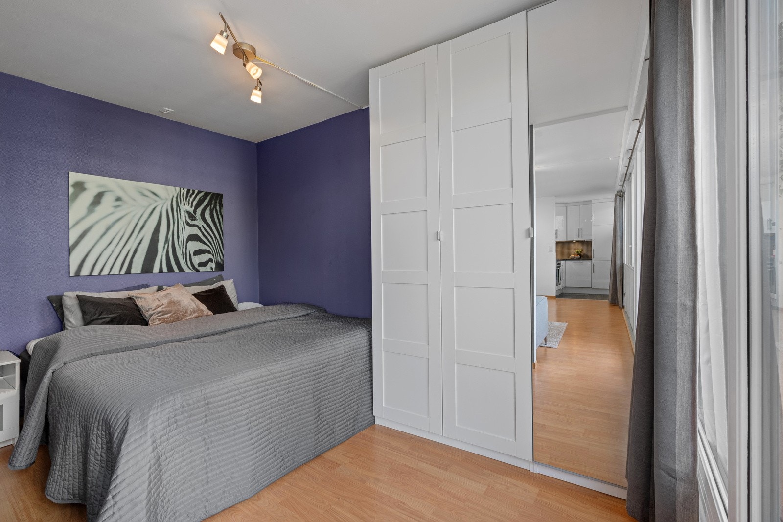 Smart plassert sovealkove som er tilbaketrukket fra stuen, med plass til dobbeltseng og oppbevaring. Galleribilde