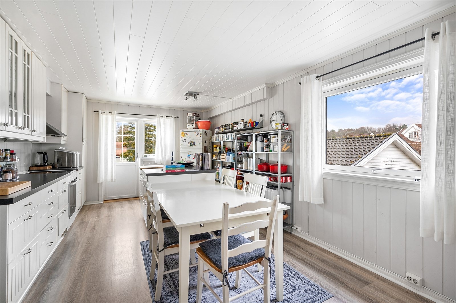 Kjøkken med hvite tidløse overflater. God plass til oppbevaring. Galleribilde