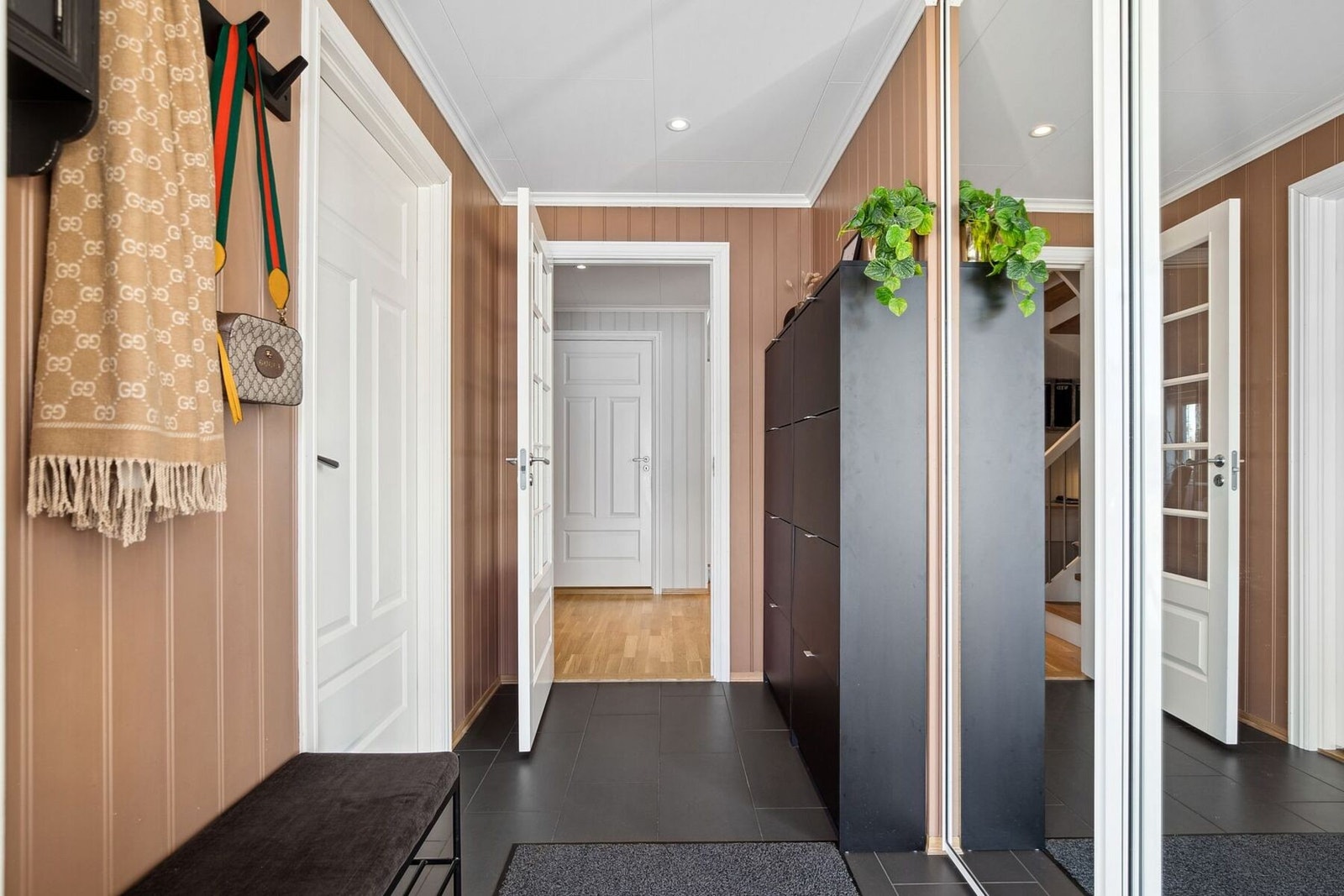 Innbydende entré med flislagt gulv og stor skyvedørsgarderobe. Galleribilde