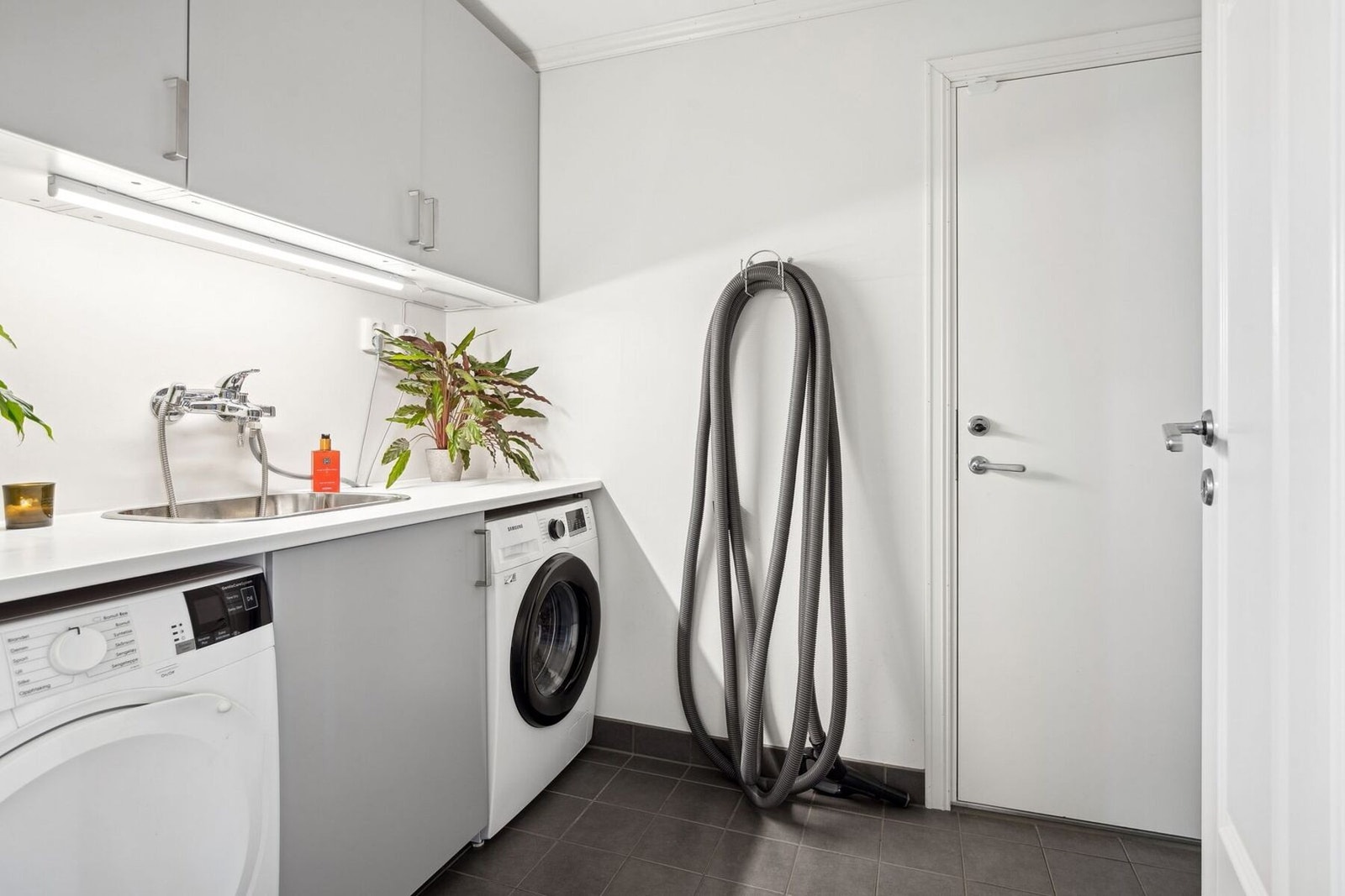 Praktisk vaskerom, med utslagsvask og opplegg for vaskemaskin og tørketrommel. Galleribilde